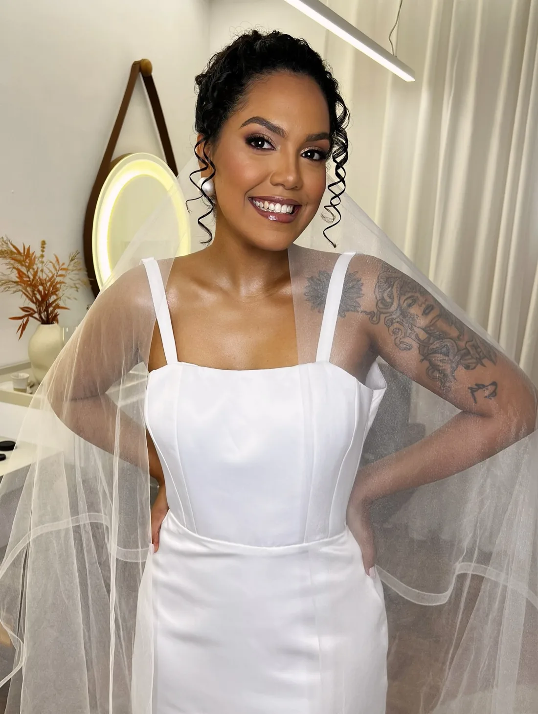 Noiva Natália com véu e penteado preso, no espaço do Beleziara
